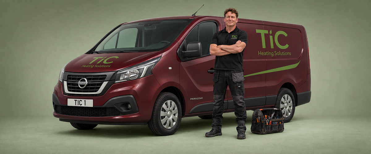 TiC Heating engineer standing beside a burgundy Nissan Primastar van.